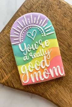 a wooden cutting board topped with a piece of paper that says you're really good mom