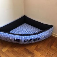 a blue and black dog bed with the word meucantino written on it