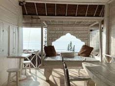 a table and chairs in a room by the ocean