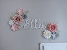 a baby's name sign with flowers on the wall