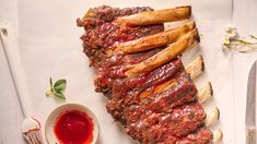 some meat is sitting on a cutting board next to a knife and fork with ketchup