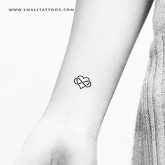 a small black and white tattoo on the wrist