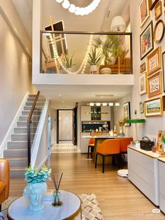 a living room filled with furniture and framed pictures on the wall above it's stairs