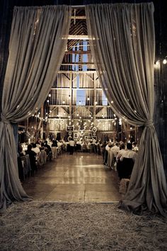 the inside of a barn with people sitting at tables