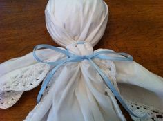 a white bag with blue ribbon on top of a wooden table