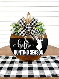 a wooden sign that says hello hunting season with a deer head and plaid bow on it