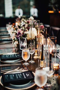 a long table is set with wine glasses and place settings for an elegant dinner party