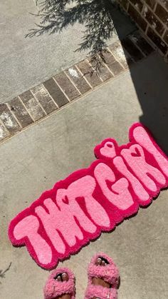 a pair of pink slippers sitting on top of a sidewalk next to a pink rug