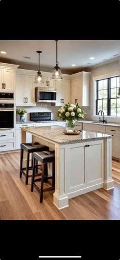 a large kitchen with an island and two stools