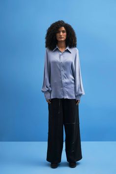 This oversized button up shirt is a statement of quintessential contemporary aesthetic. Featuring batwing inspired sleeves, rock this style for an avant-garde look.Black Shell: 100% CottonSteel Blue Shell: Modal SatinMade In IndiaDry Clean OnlyModel is wearing Size M, Height 5'9 Modern Blue Blouse For Office, Modern Oversized Blouse For Office, Chic Oversized Blue Blouse, Blue Blouse With Balloon Sleeves For Work, Blue Tops With Cuffed Sleeves For Fall, Modern Blue Long Sleeve Blouse, Modern Oversized Formal Blouse, Oversized Blouse For Night Out In Fall, Oversized Modern Formal Blouse