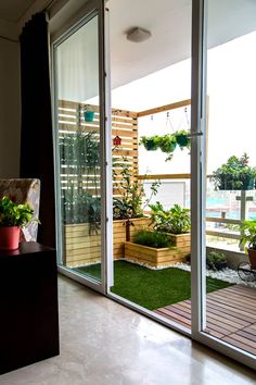 an open patio with potted plants on the ground and sliding glass doors leading outside