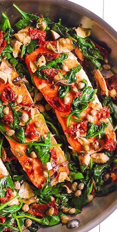 a pan filled with fish and spinach covered in sauce