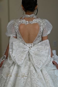 the back of a woman's wedding dress with a large bow at the waist