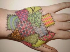 a person's hand with colorful tattoos on it