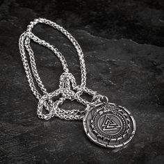 This stainless steel necklace is perfect for those who want to add a little bit of mythology to their wardrobe. The shield style pendant features the mythical serpent Jormungand, encircling a Valknut symbol. Whether you're dressing up for a day at the office or dressing down for a night out on the town, this necklace is sure to make a statement. Also features a Helm of Awe on the reverse with the inscription: "The brave shall live forever in the halls of Valhalla" Pendant is approx. 1.5" across Symbolic Silver Tarnish Resistant Medallion Necklace, Symbolic Silver Medallion Necklace, Symbolic Silver Medallion Necklace Tarnish Resistant, Symbolic Silver Tarnish-resistant Medallion Necklace, Viking Style Engraved Metal Necklaces, Viking Style Silver Stainless Steel Jewelry, Viking Style Silver Round Pendant Necklace, Viking Style Silver Stainless Steel Necklaces, Silver Viking Stainless Steel Necklaces