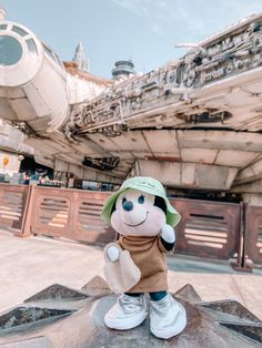 a stuffed animal is sitting on top of a table in front of a star wars ship