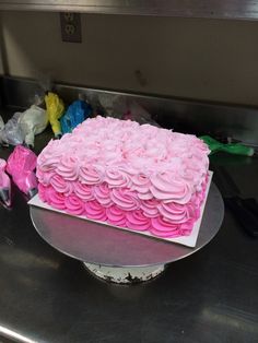 a pink cake sitting on top of a metal platter