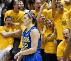 a group of women in yellow and blue uniforms standing next to each other on a basketball court