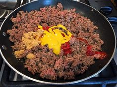 a frying pan filled with meat and vegetables on top of a gas stovetop