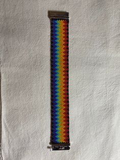 a multicolored bracelet is displayed on a white cloth