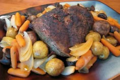 a plate with meat, potatoes and carrots on it