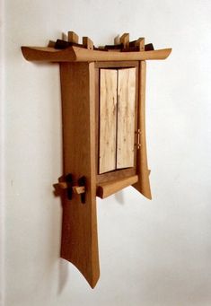 a wooden clock mounted to the side of a wall