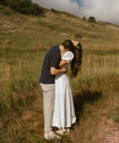 a man and woman kissing in a field