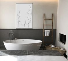 a white bath tub sitting in a bathroom next to a painting on the wall above it