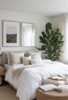 a bed with white linens and pillows in a bedroom next to a large window