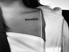 a woman with a tattoo on her chest that says, breathe thin and has the word breathe