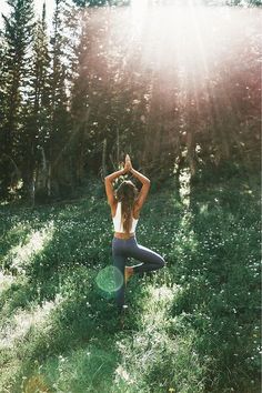 a woman is doing yoga in the woods