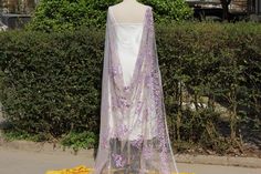 a mannequin wearing a purple and white dress with flowers on it's back