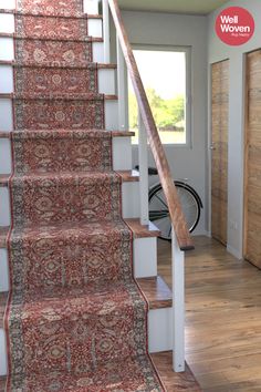 a stair case with carpet on it in a room next to a door and bicycle