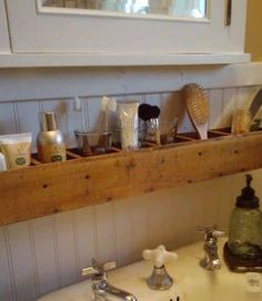 a bathroom sink with soap, toothbrushes and other items on the shelf above it