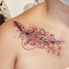 a woman's chest with pink flowers and dots on the top part of it