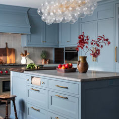 a kitchen with blue cabinets and marble counter tops