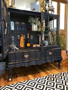 an antique china cabinet with glass doors and gold trimmings on the top shelf