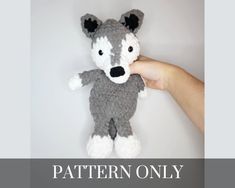 a hand holding a gray and white crocheted stuffed animal with the words pattern only on it