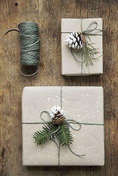 presents wrapped in white paper with pine cones and twine