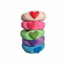 a stack of multicolored donuts with hearts on them