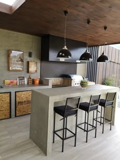 an outdoor kitchen with bar stools next to the counter and cabinets in front of it