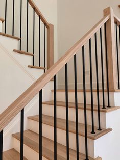 a wooden stair case with black handrails in a home's entryway