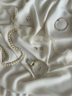 a white satin with pearls and jewelry on it