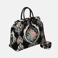 a black and white handbag with floral designs on the front, shoulder strap and handle