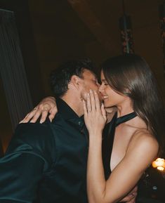 a man and woman kissing each other at a party