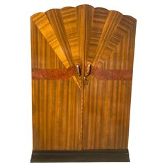 an art deco style wooden cabinet with two doors and leather straps on the front door