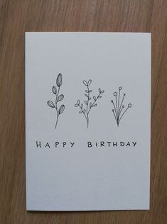 a card with three flowers on it that says happy birthday, and the words are written in black ink