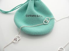 Offered for sale is a gorgeous and classic Tiffany & Co. Sterling Silver 1837 Interlocking Multi Circles necklace. The piece is crafted from bright and substantial Tiffany silver. Great and unique way to say "I love you" or "I love me :)!". It is a wonderful necklace that fits a lifestyle on the go -- the necklace can be worn to almost any occasion! It is simple, elegant, and classic all rolled into one necklace. Imagine the piece with your professional office attire ... Now imagine it with Interlocking Circle Necklace, I Love Me, Professional Office, Gift Pouch, Circle Necklace, Say I Love You, Necklace Chain, Love Me, Tiffany & Co.