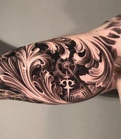 a man's arm covered in black and white ink with a clock on it