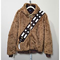 Star Wars Chewbacca Faux Fur Zip Cosplay Halloween Costume Hoodie Jacket Sz M -Long Sleeve, Thick Brown Faux Fur Hoodie/Jacket With A Full Front Zipper Closure, Drawstring Tie At The Neck, And Ribbing On The Cuff Sleeves And Hemline -Features Include An Embroidered Diagonal Bandolier Design In A Darker Brown, White And Yellow Color On The Front And Back Of The Garment, Along With Side Seam Pockets On The Left And Right Side Of Hoodie Just Above The Hemline -Hoodie Is Lined Inside, Is In Great Co Winter Costume Outerwear With Faux Fur Lining, Brown Winter Outerwear For Cosplay, Starwars Coat, Anakin Skywalker Hood Up, Star Wars Patch Jacket, Chewbacca Pillow, Fur Hoodie Jacket, Star Wars Jacket, Faux Fur Hoodie